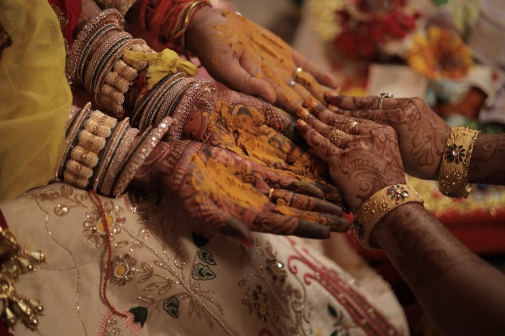 pexels-photo-13273850 Close-up of hands with henna and turmeric during a traditional ceremony, showcasing cultural details.