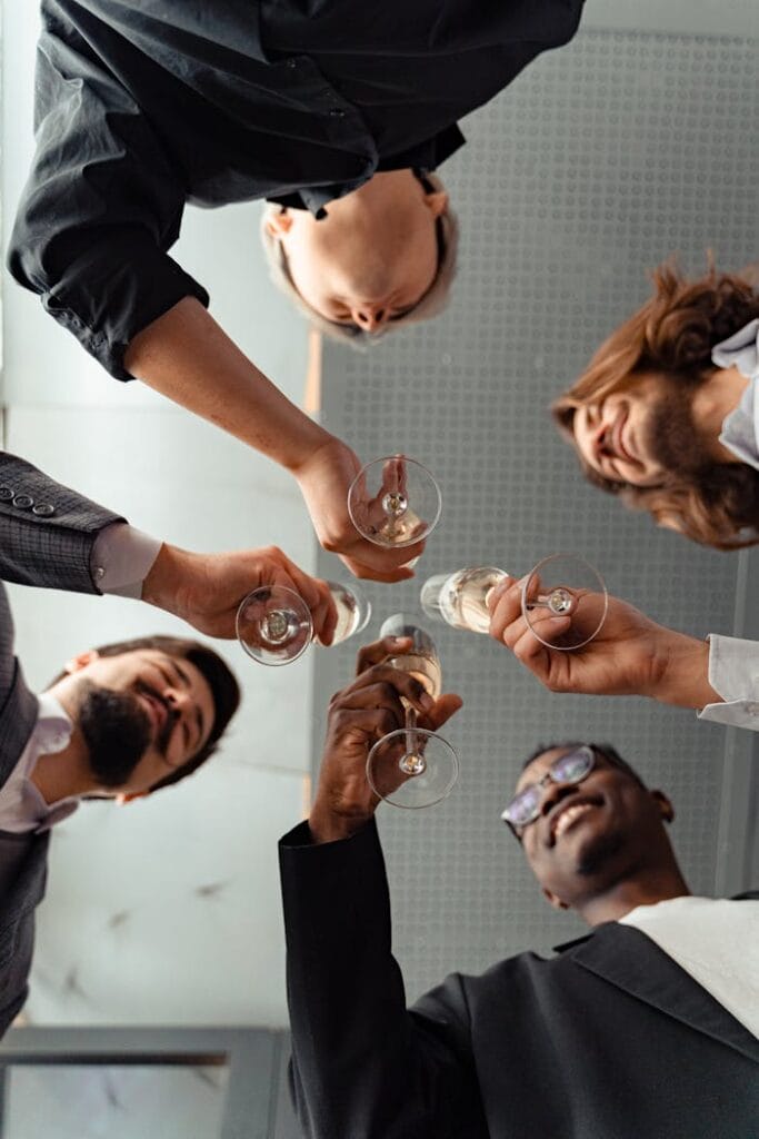 pexels-photo-6759180 A diverse group of adults clinking champagne glasses in celebration, viewed from below.